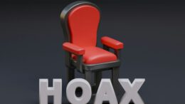 a red chair sitting next to the word hoax
