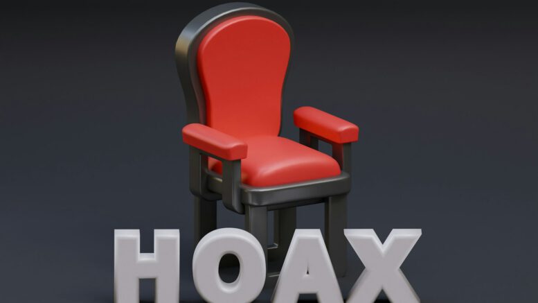 a red chair sitting next to the word hoax