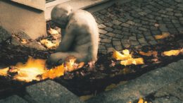 a teddy bear sitting on the ground in front of a building
