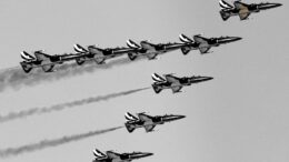 a group of fighter jets flying through a cloudy sky
