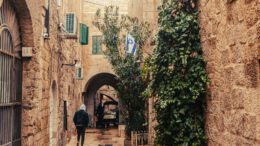 a man walking down a narrow alley way