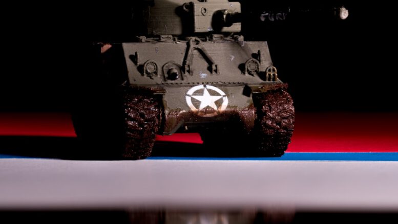 A toy army vehicle sitting on top of a table
